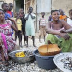 Femmes qui transforment les coquillages accompagnées de leurs enfants