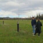 Prairie parsemée de plantations agroforestières, observée par un homme et une femme