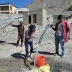 Test de la pompe à eau dans un internat du Ladakh en présence de 3 hommes